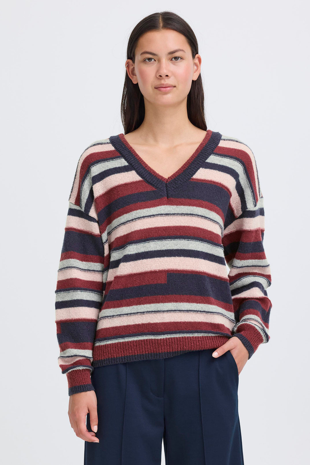 Woman wearing a striped sweater with a plain background