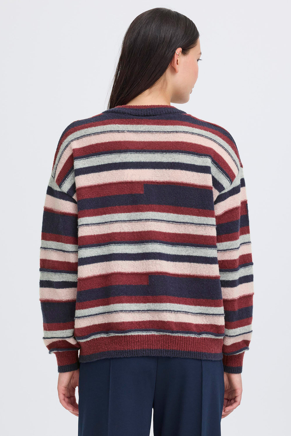 Person wearing a striped sweater with a neutral background