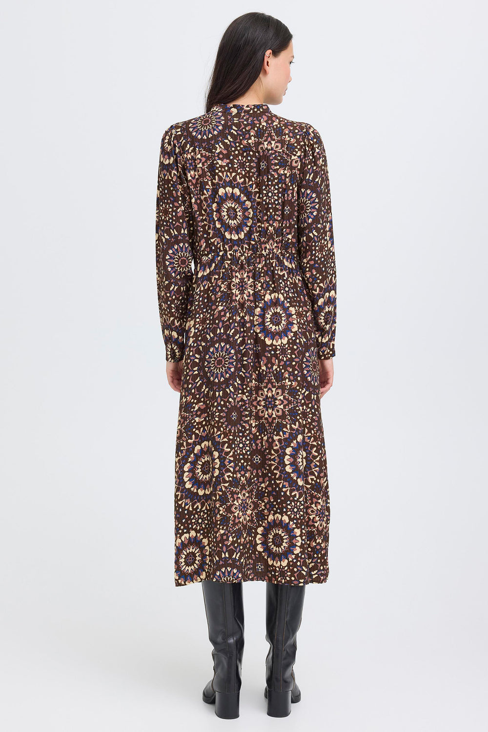 Woman wearing a long, patterned dress on a white background