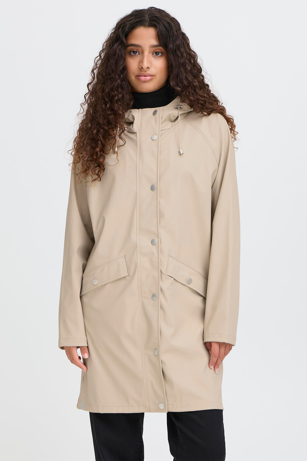 Woman wearing a beige coat on a white background