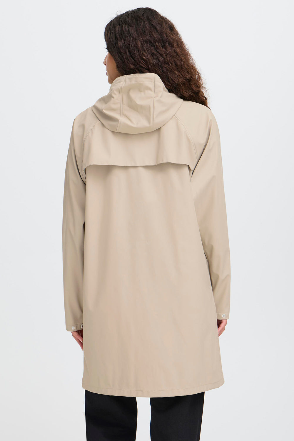Person wearing a beige raincoat on a white background