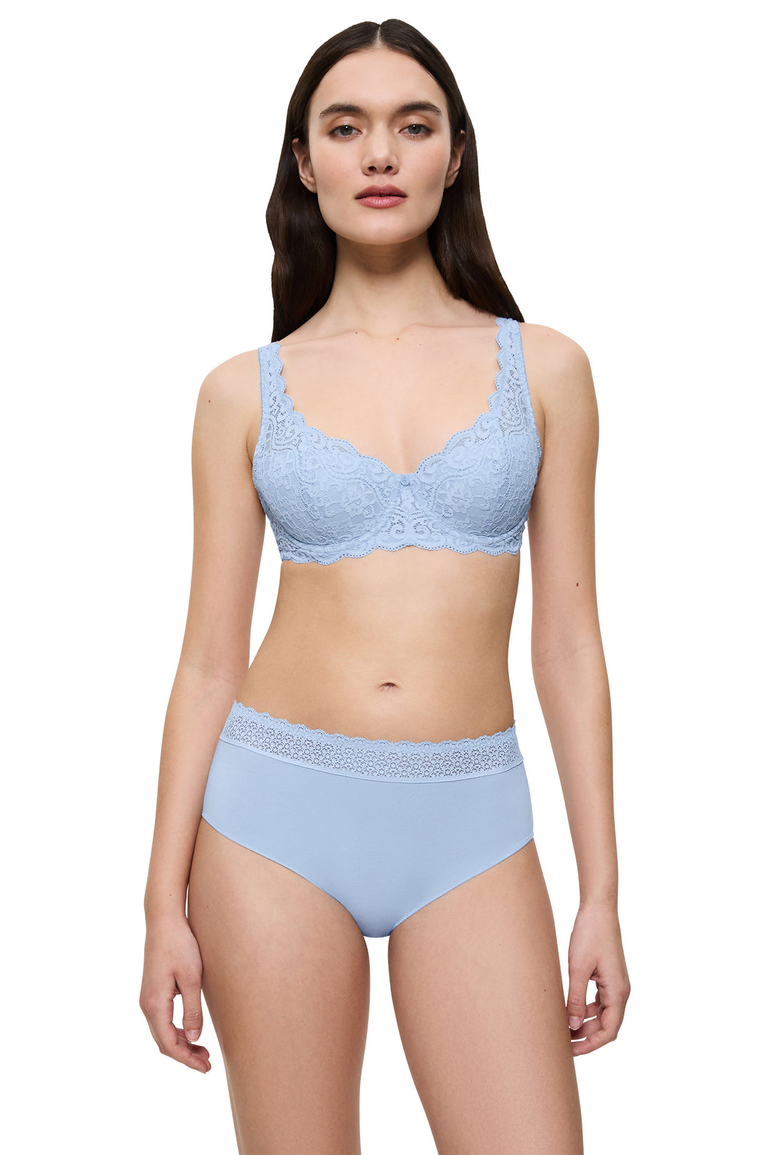 Woman wearing a light blue lace bra and panties set on a white background