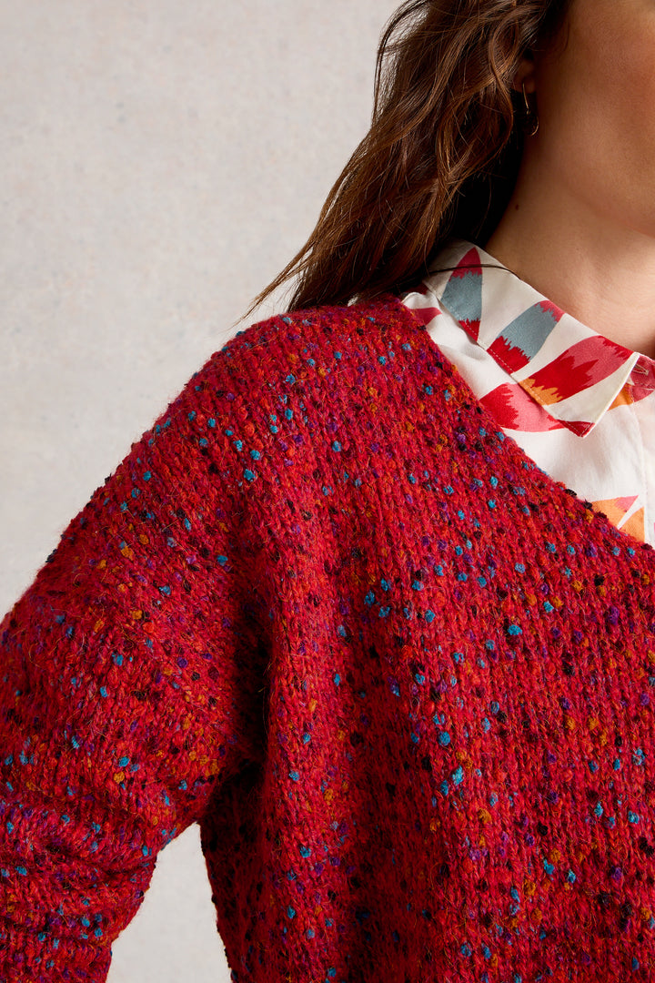 Red textured sweater with a patterned collar against a neutral background