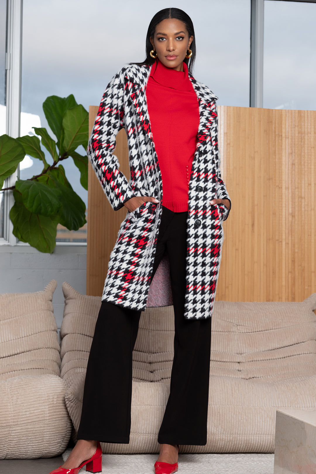 Woman wearing a houndstooth patterned coat in an indoor setting
