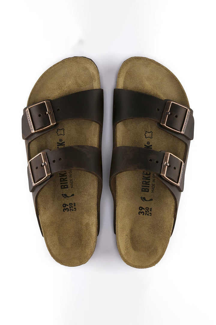 Pair of brown sandals with black straps on a white background