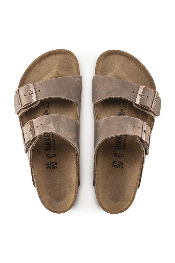 Pair of brown sandals with double buckles on a white background