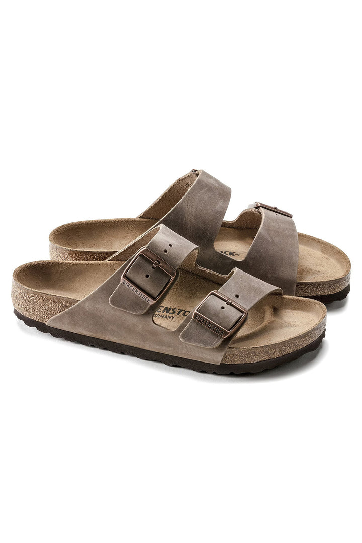 Pair of brown sandals with double straps on a white background