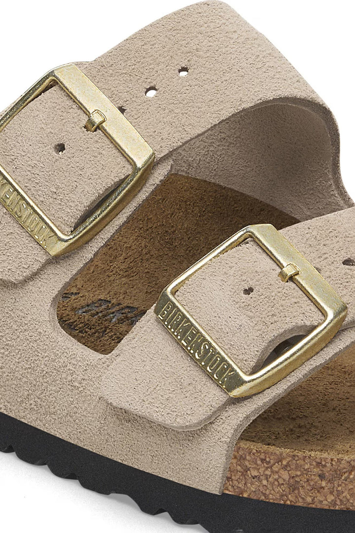 Beige sandals with gold buckles on a white background
