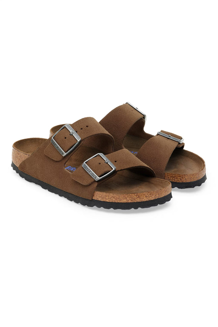 Pair of brown sandals with buckles on a white background