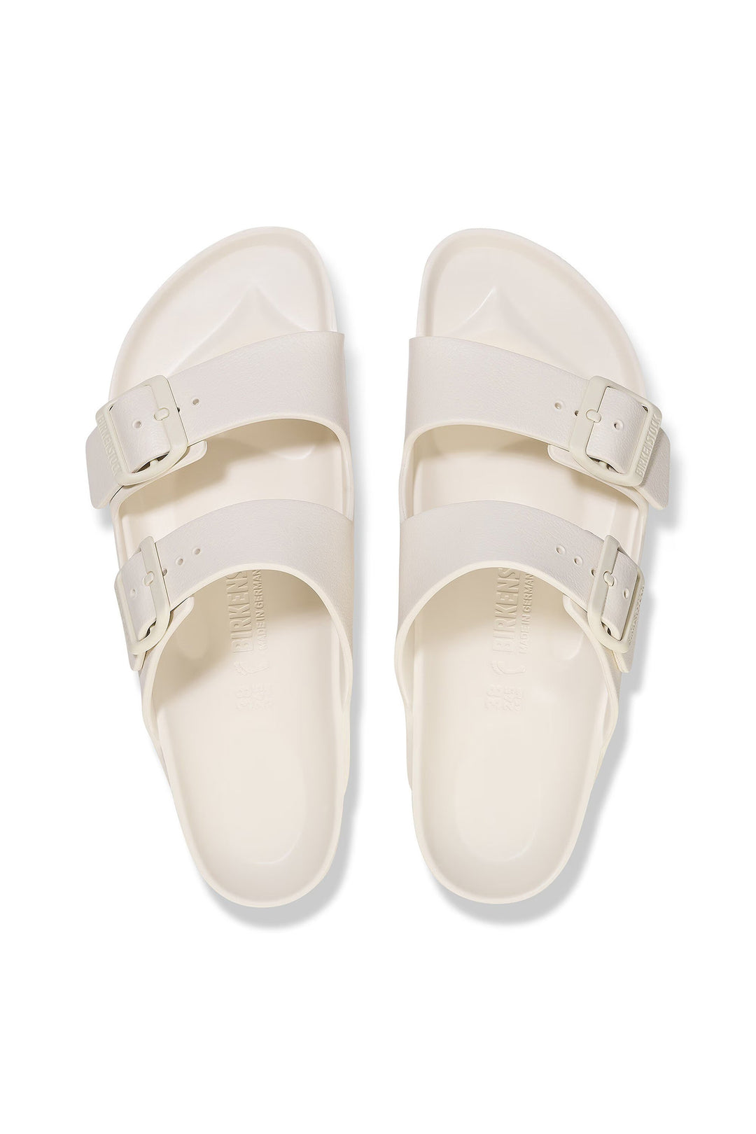 Pair of white sandals with buckles on a white background