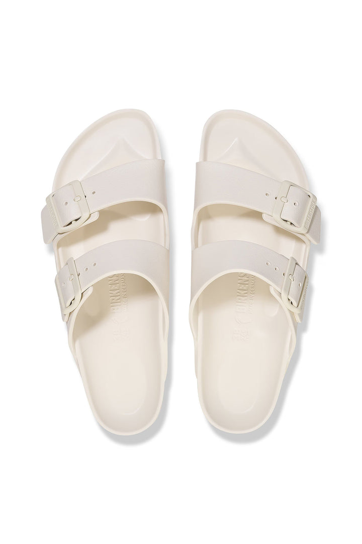 Pair of white sandals with buckles on a white background