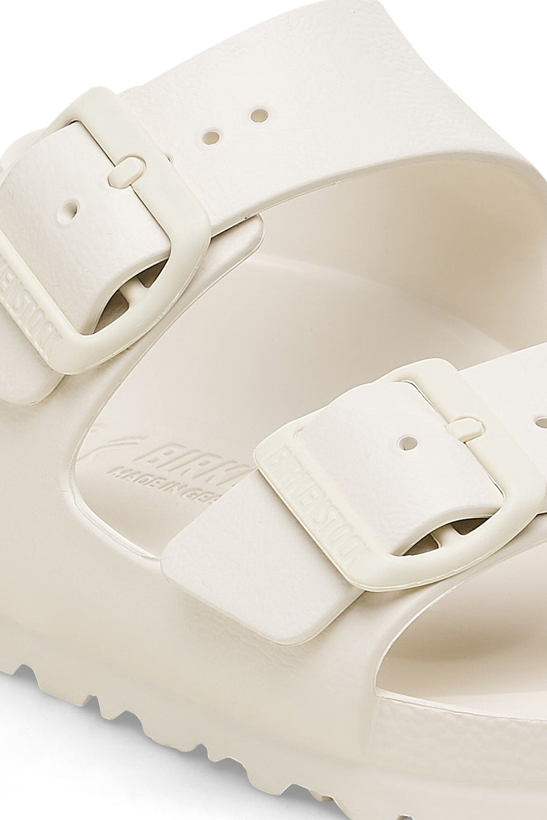 Close-up of a beige sandal with a strap on a white background