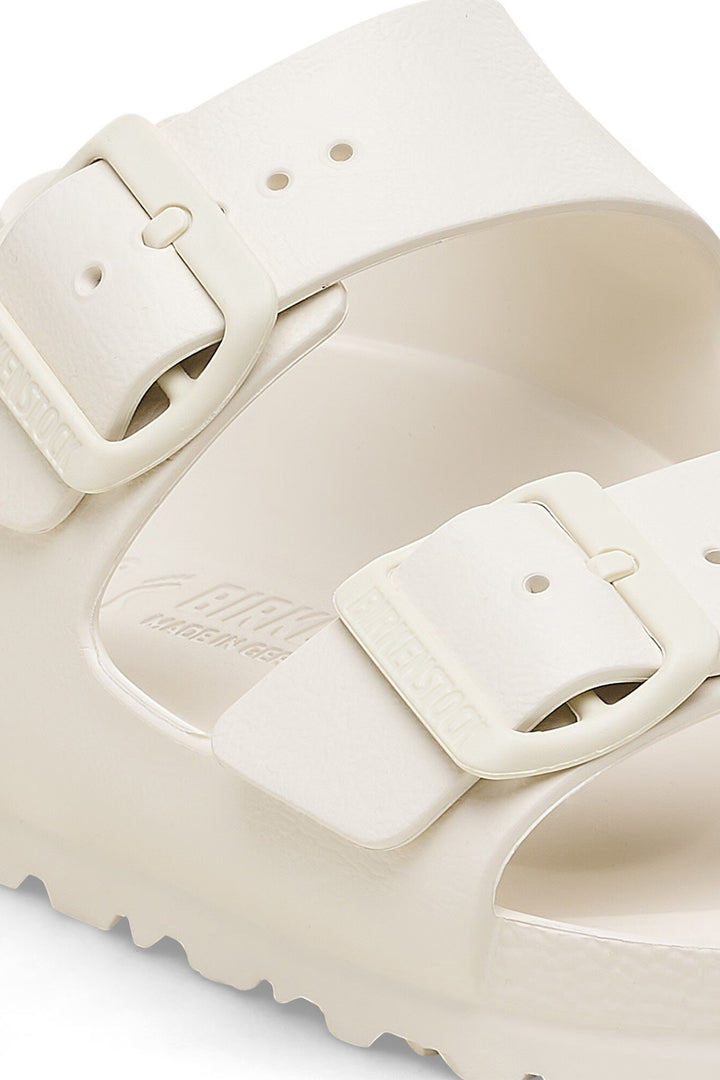Close-up of a beige sandal with a strap on a white background