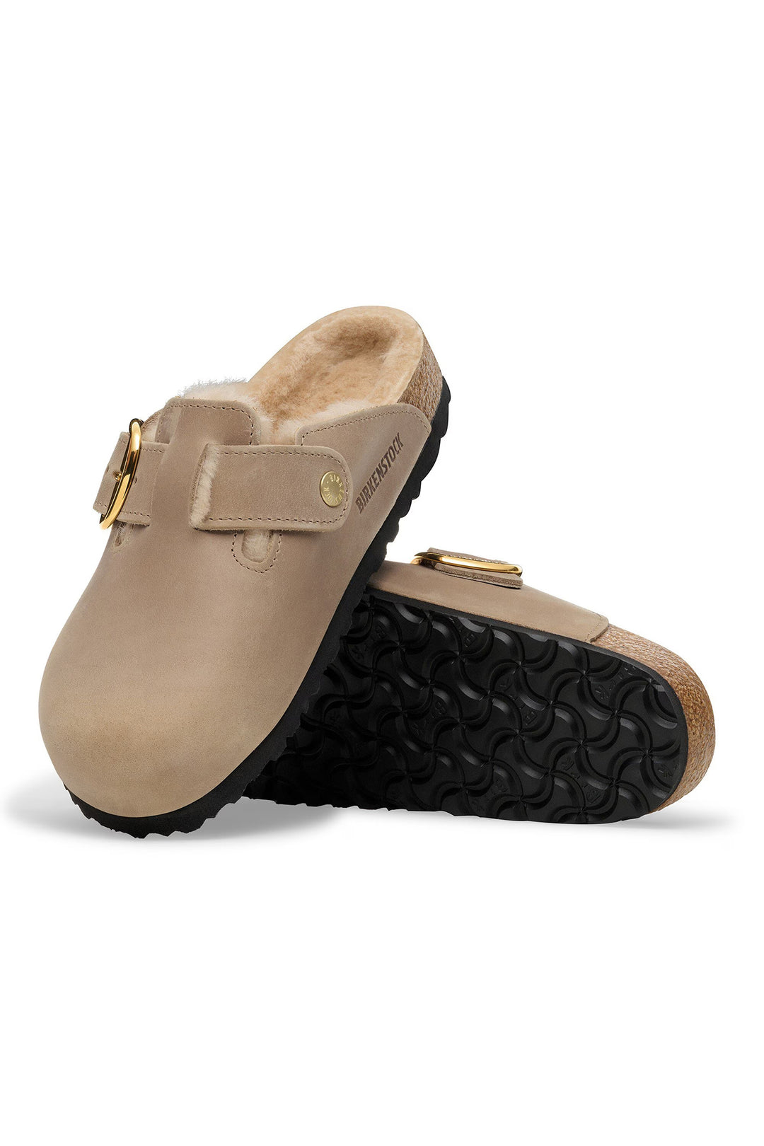 Pair of beige clogs with black soles on a white background