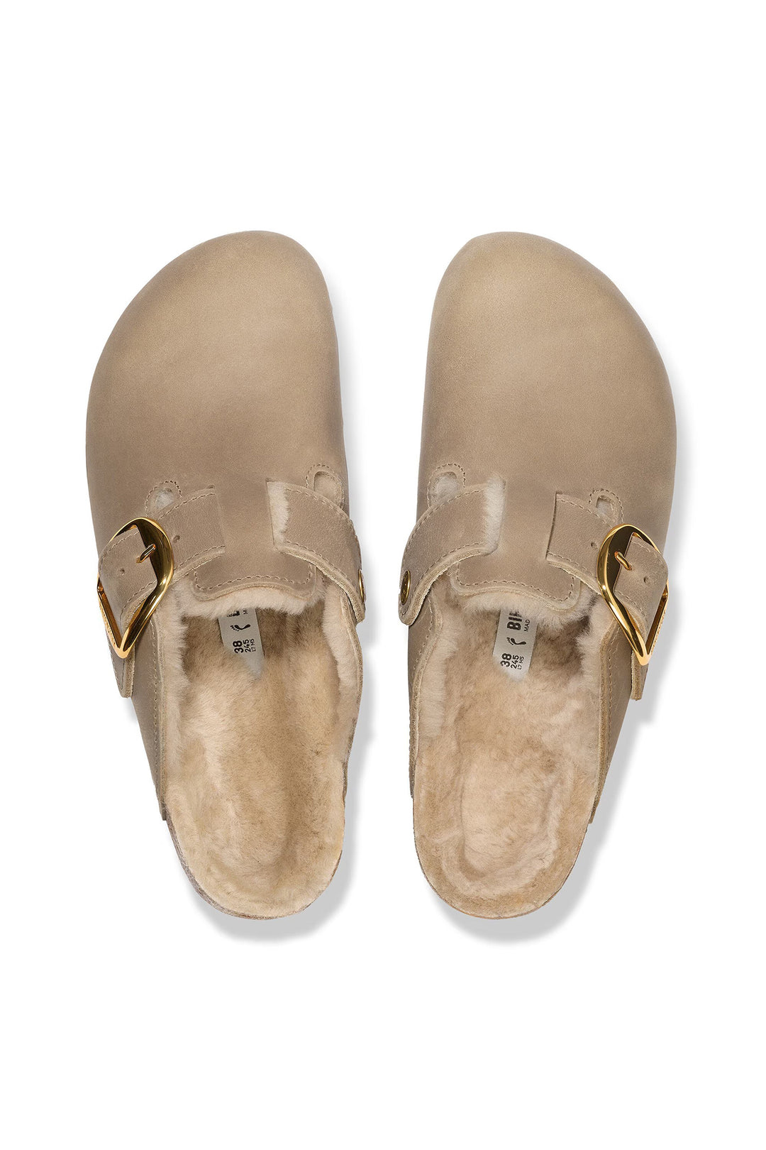 Pair of beige slippers with gold buckles on a white background
