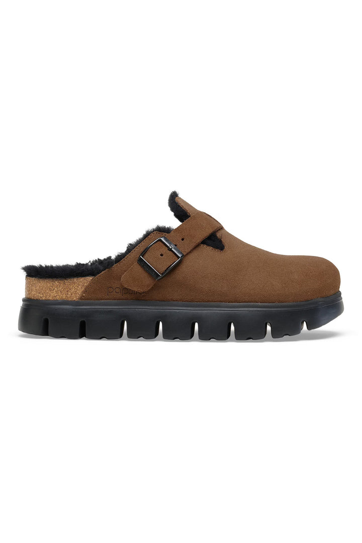 Brown clog shoe with black sole on a white background
