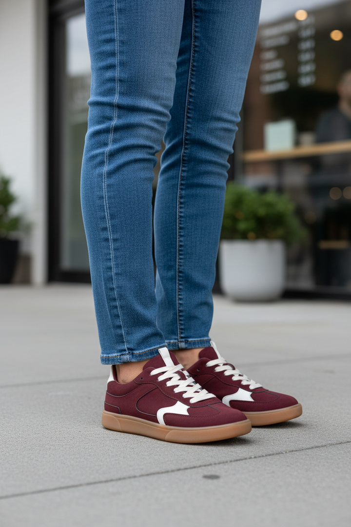 Maroon sneakers with white laces on a white background