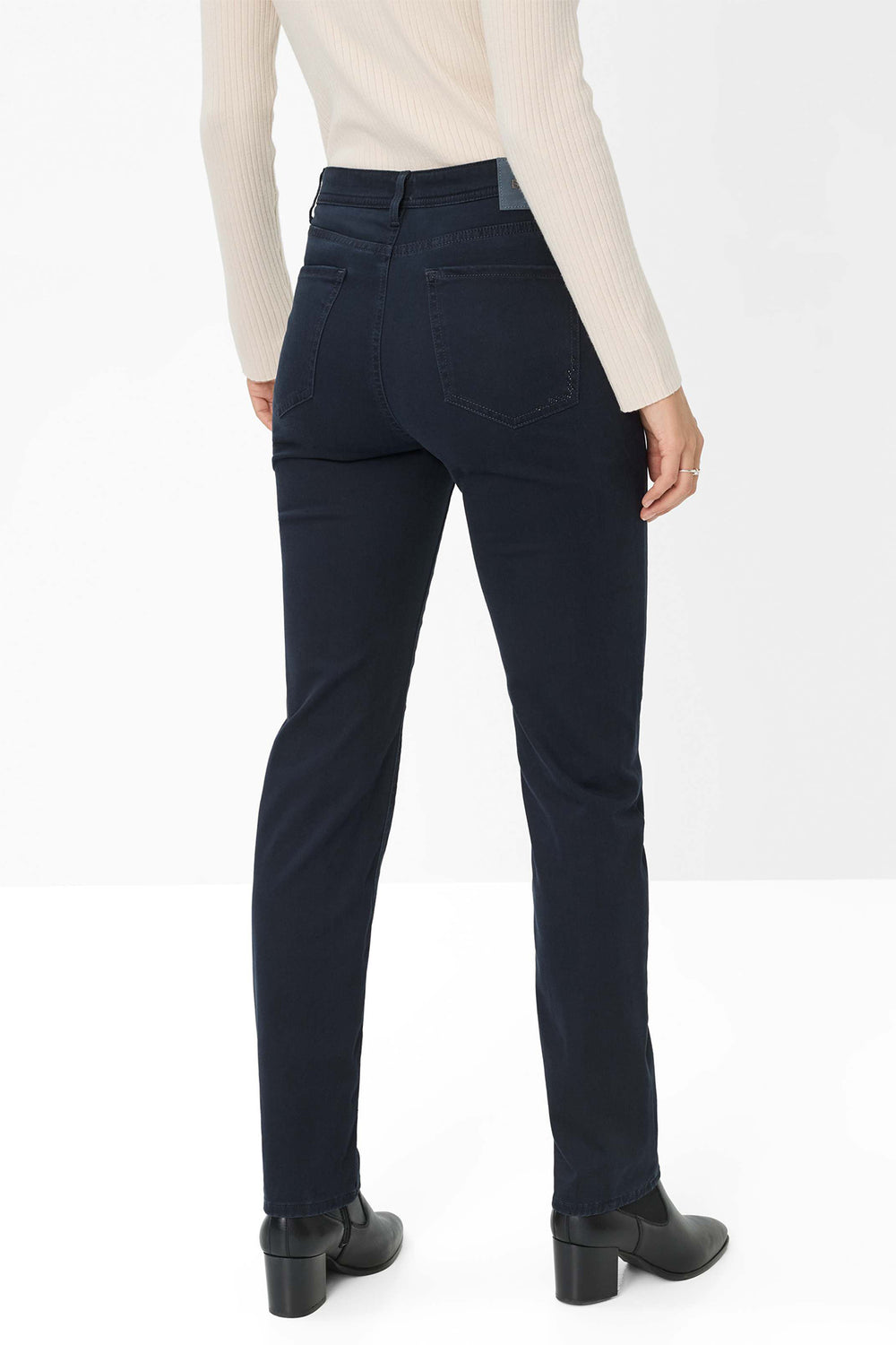 Person wearing dark blue jeans on a white background