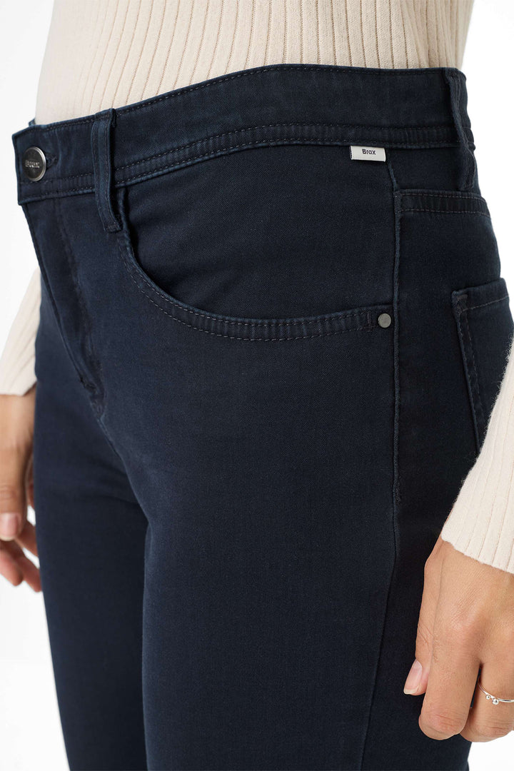 Navy blue jeans worn by a person on a white background