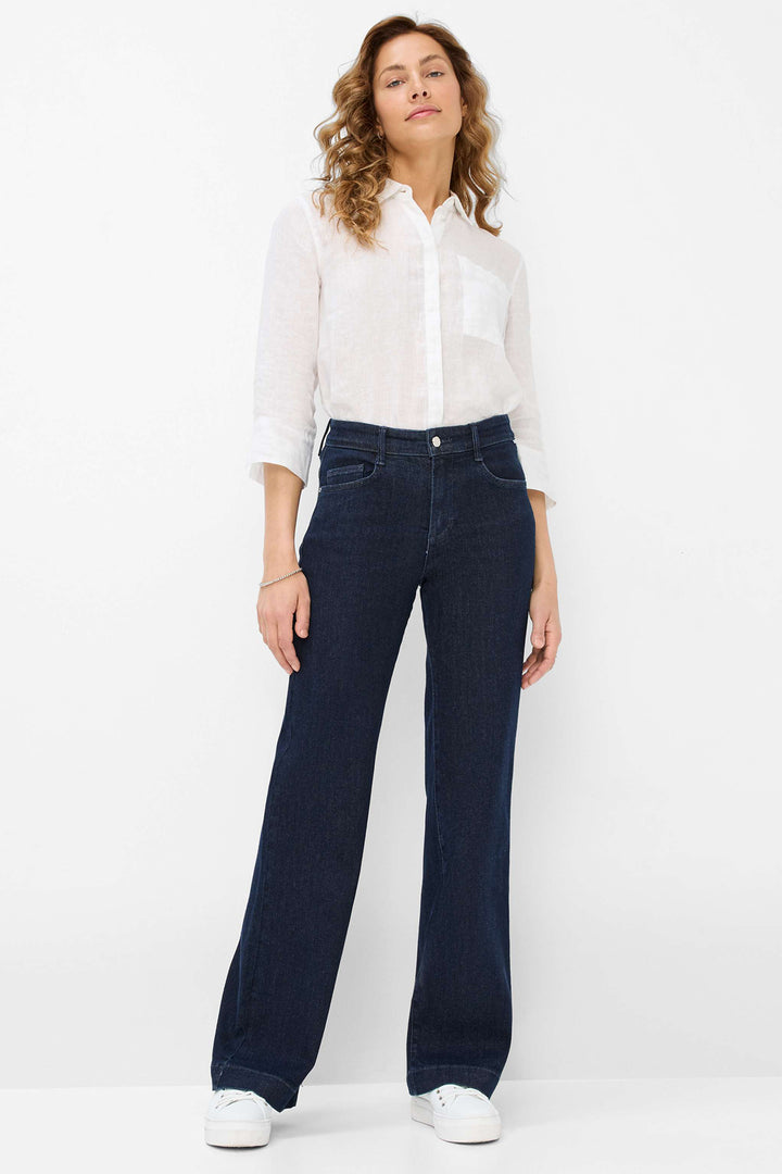 Woman wearing a white blouse and dark blue jeans on a white background