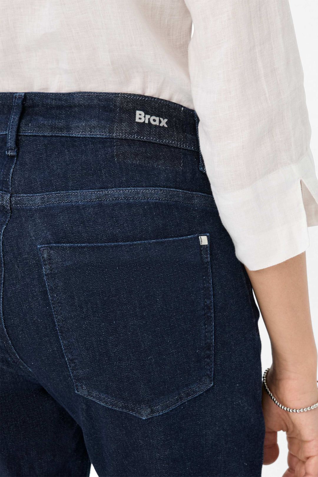 Dark blue jeans with 'Brax' branding on a white background