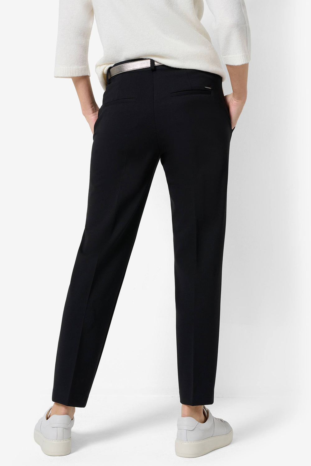 Person wearing black pants and a white top on a white background