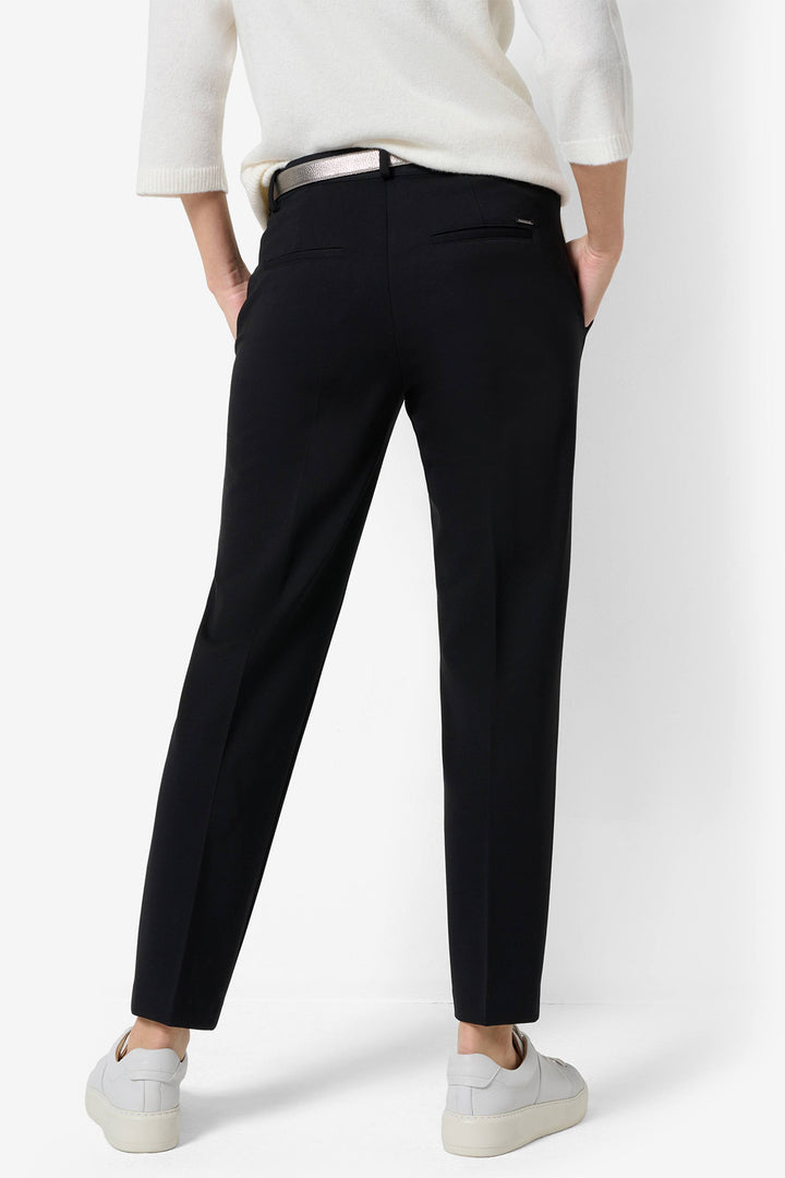 Person wearing black pants and a white top on a white background