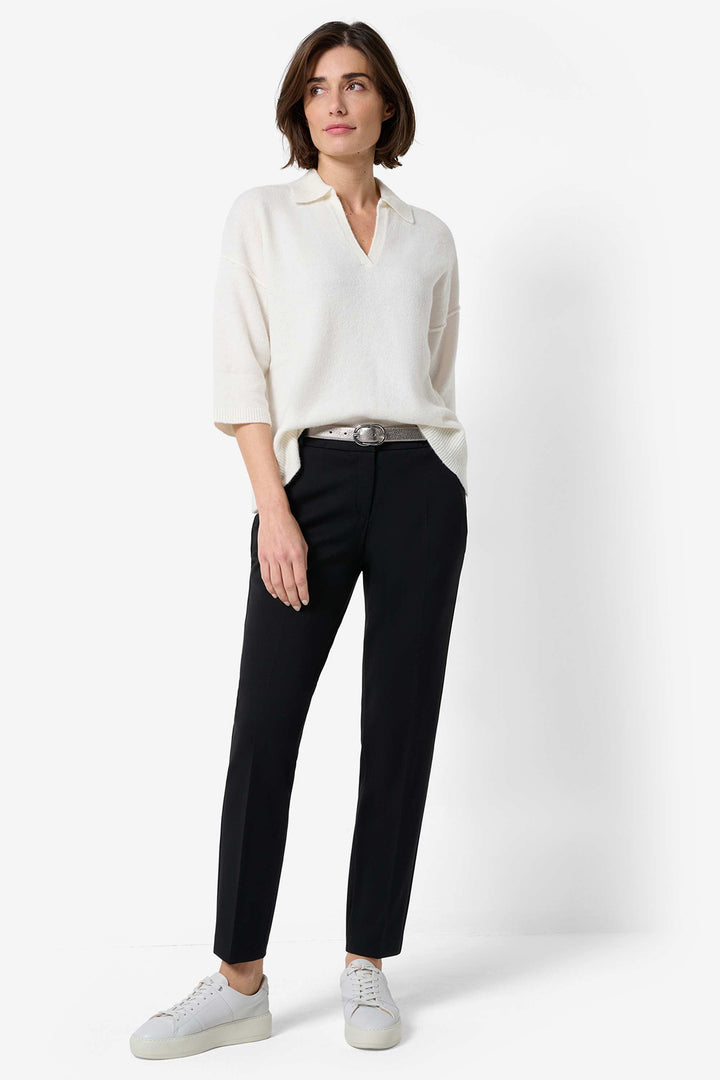 Woman wearing a white blouse and black pants on a white background