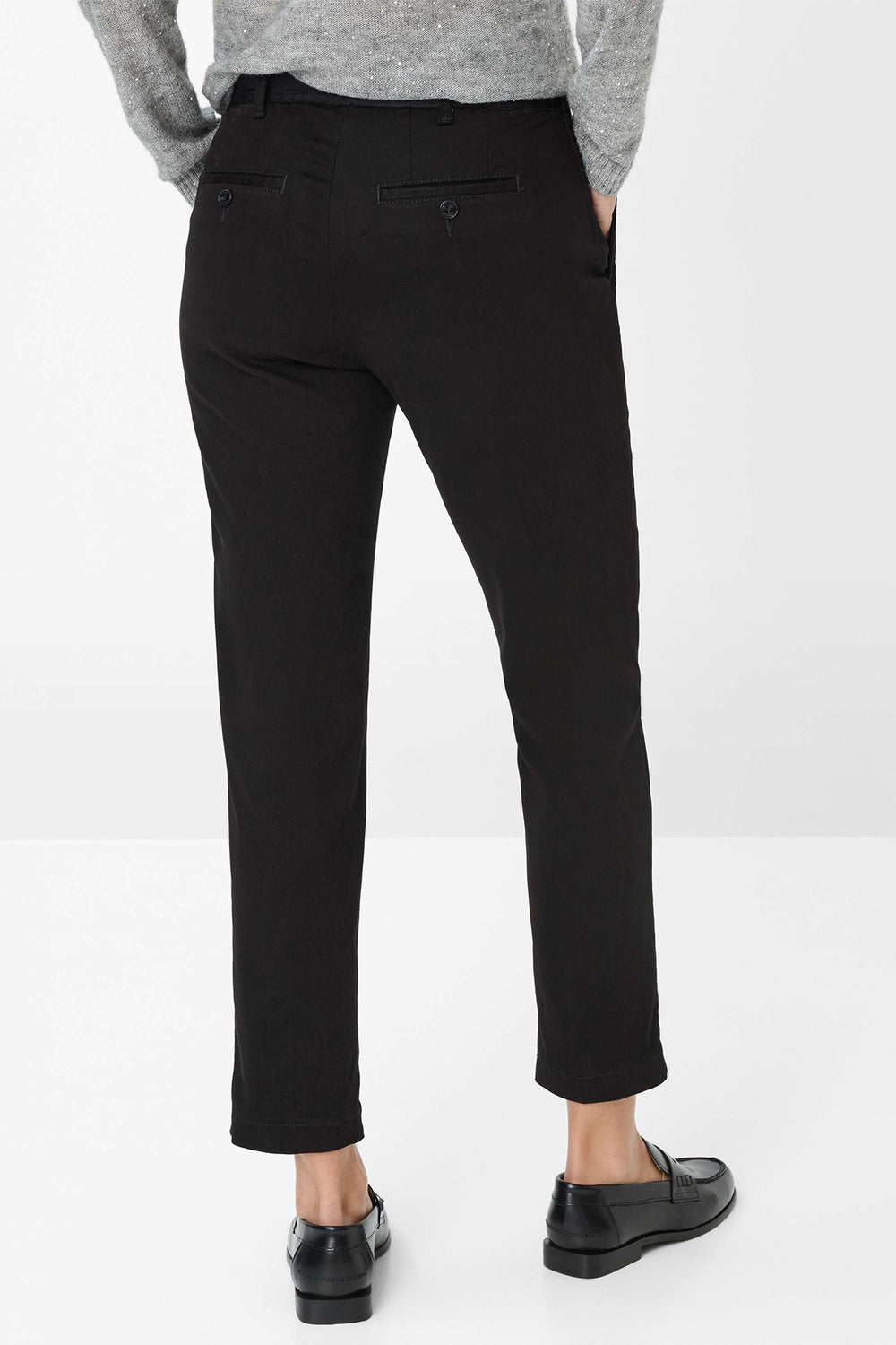 Person wearing black pants on a white background