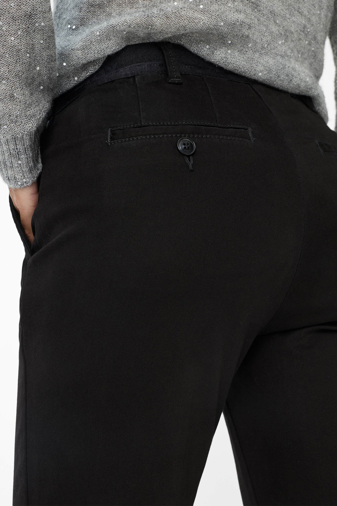 Black pants worn by a person on a white background