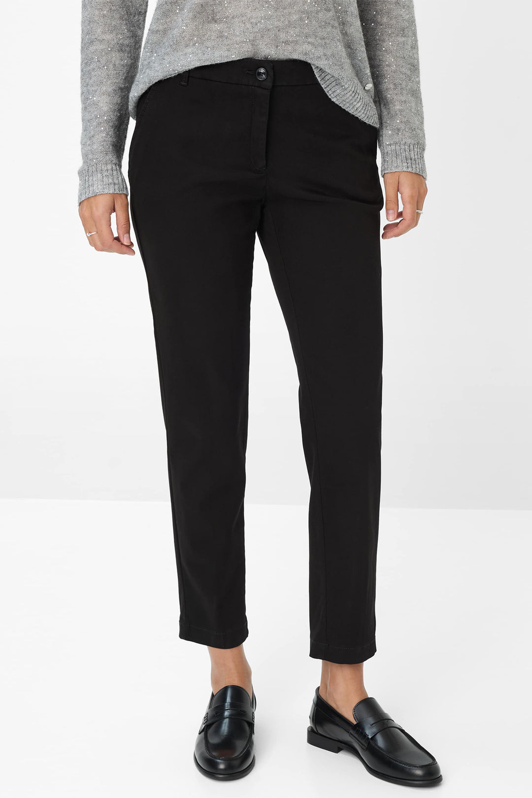 Person wearing black pants and black shoes on a white background