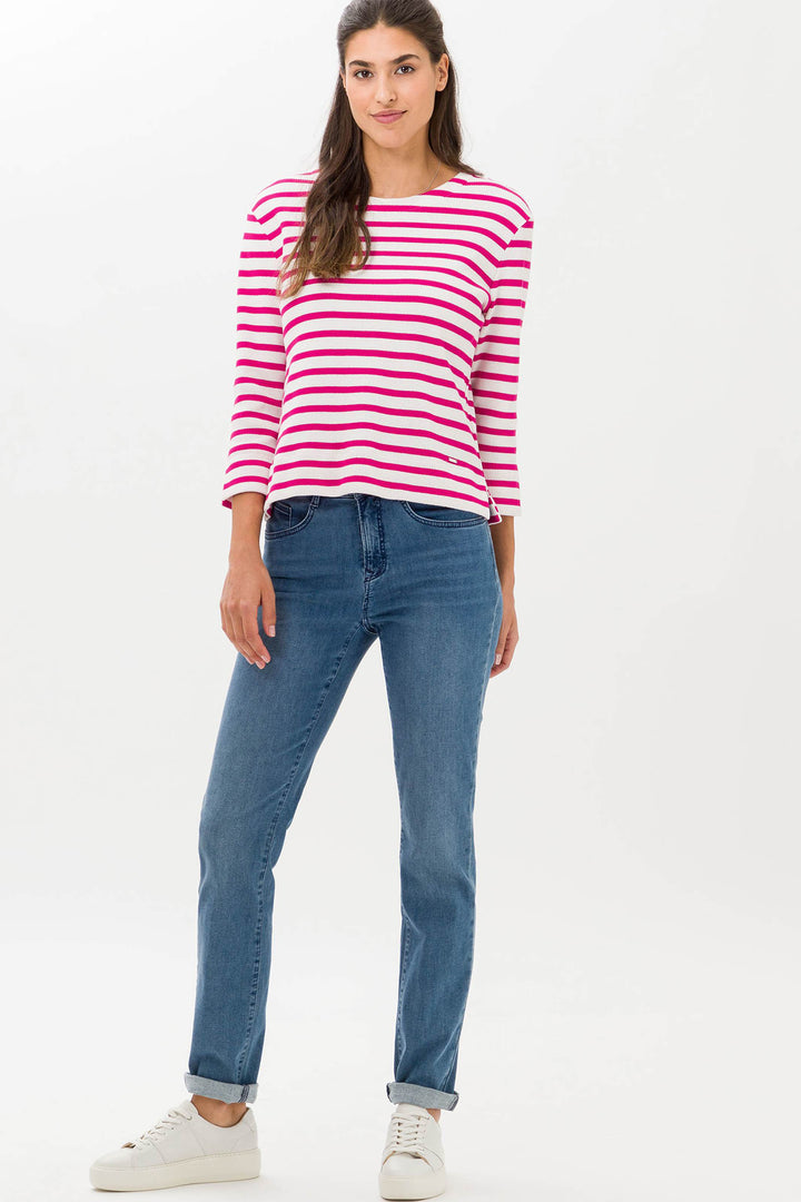Woman wearing a pink and white striped shirt and blue jeans on a white background