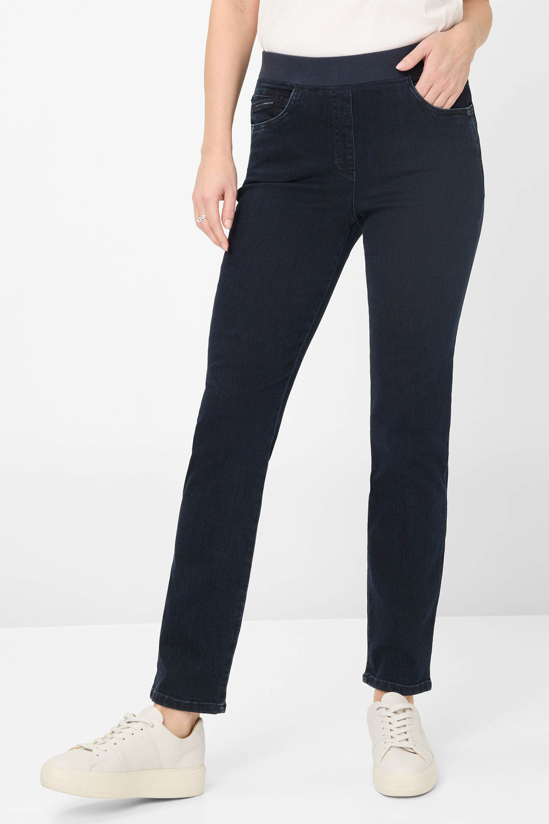 Person wearing dark blue jeans on a white background