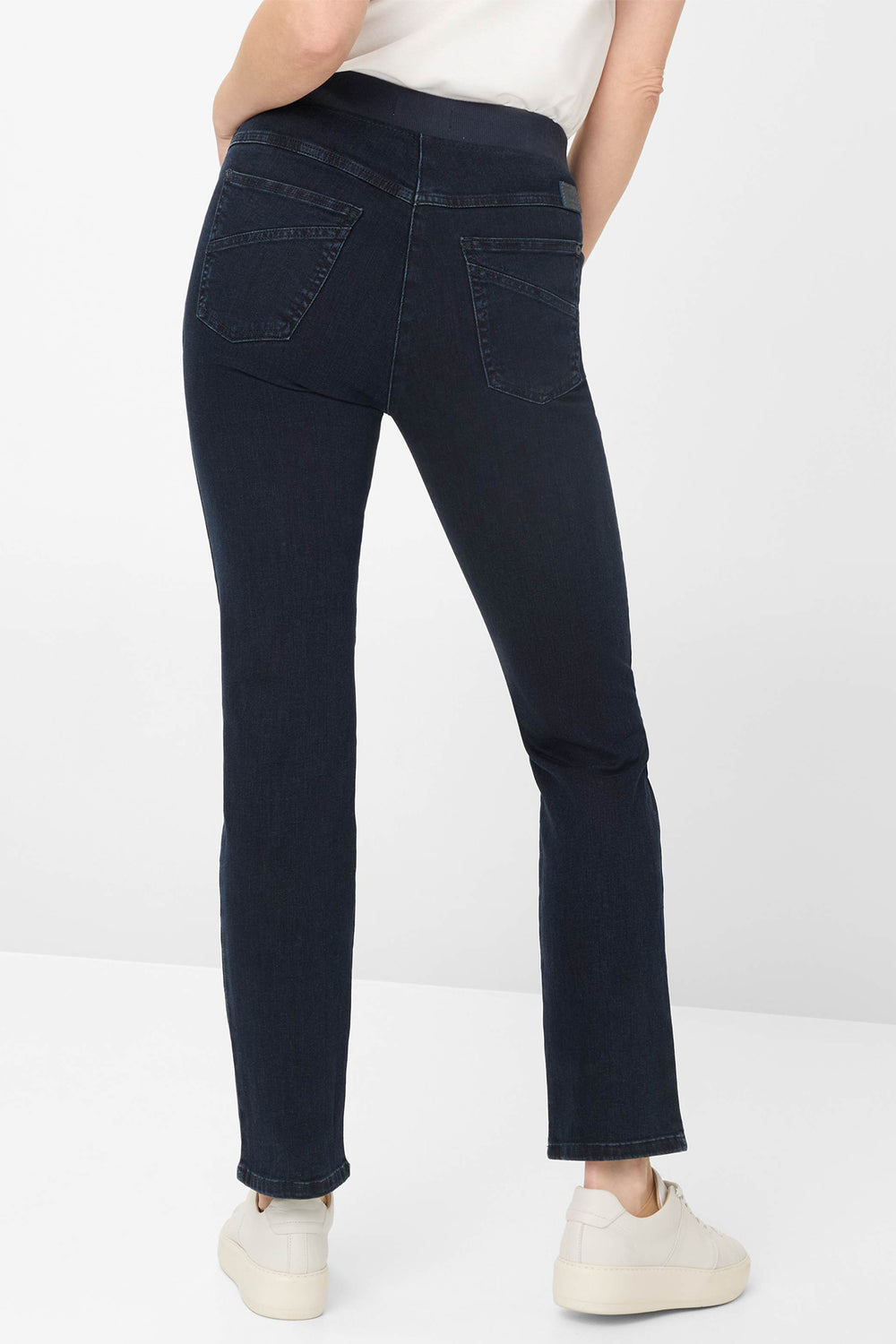 Person wearing dark blue jeans on a white background
