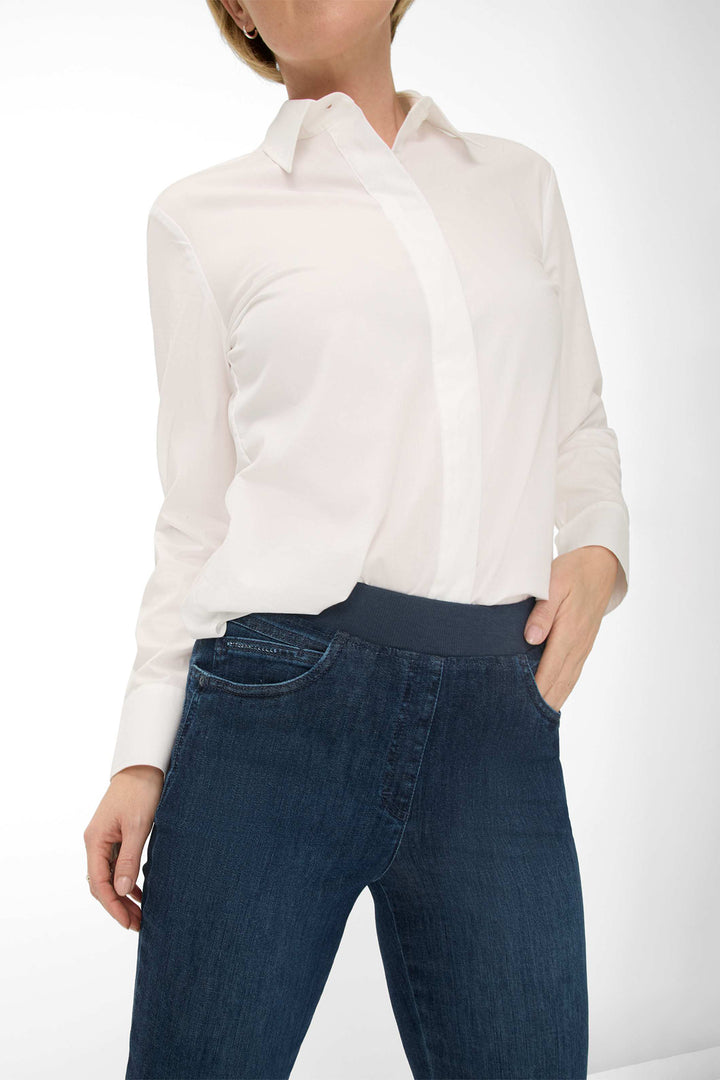 Person wearing a white shirt and blue jeans on a white background