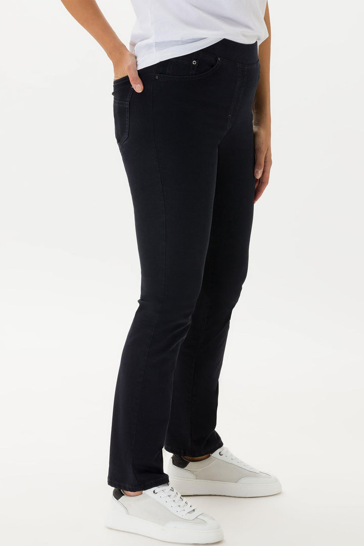 Person wearing black pants and white sneakers on a white background