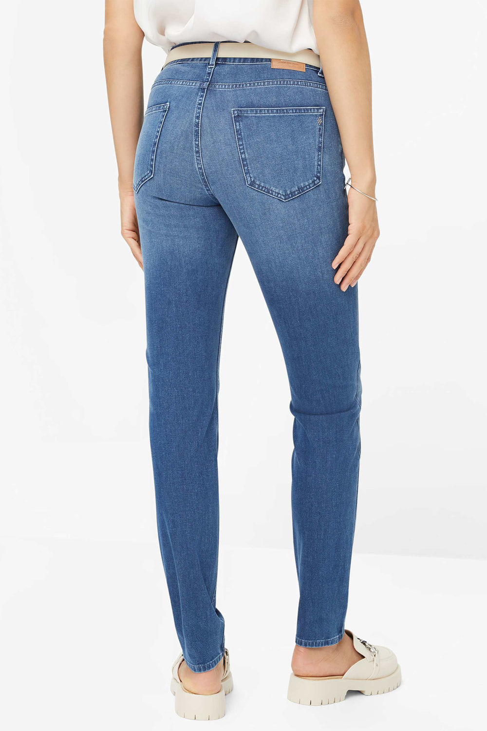 Person wearing blue jeans on a white background