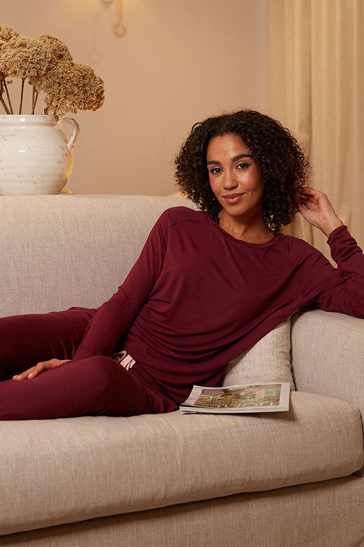 Cyberjammies 2689 Blush Botanica Berry Red Jersey Pyjama Bottoms, worn on a sofa