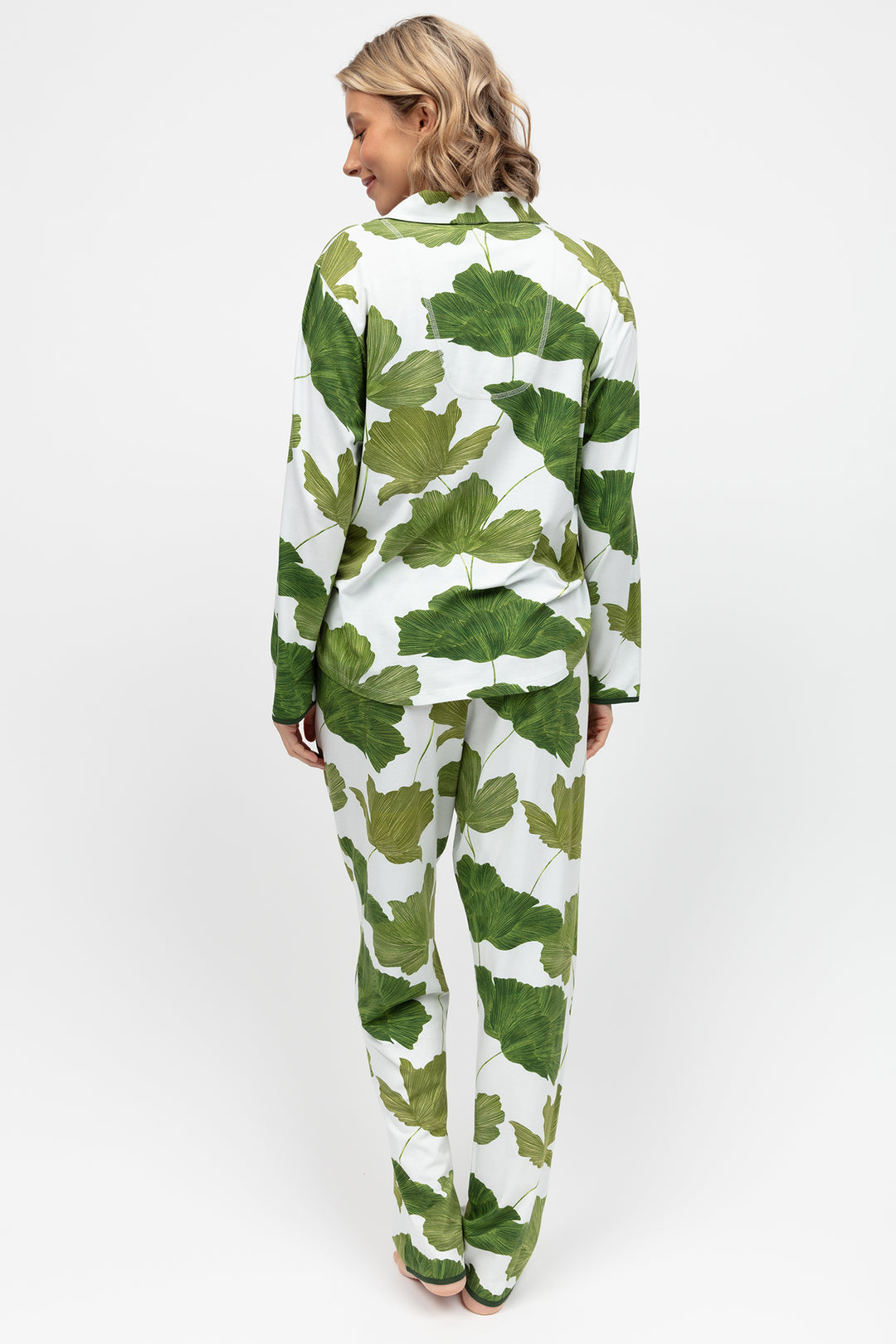 Person wearing a green and white leaf-patterned outfit on a white background