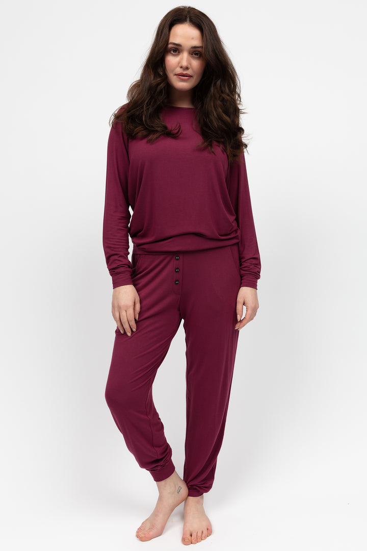 Woman wearing a burgundy loungewear set on a white background