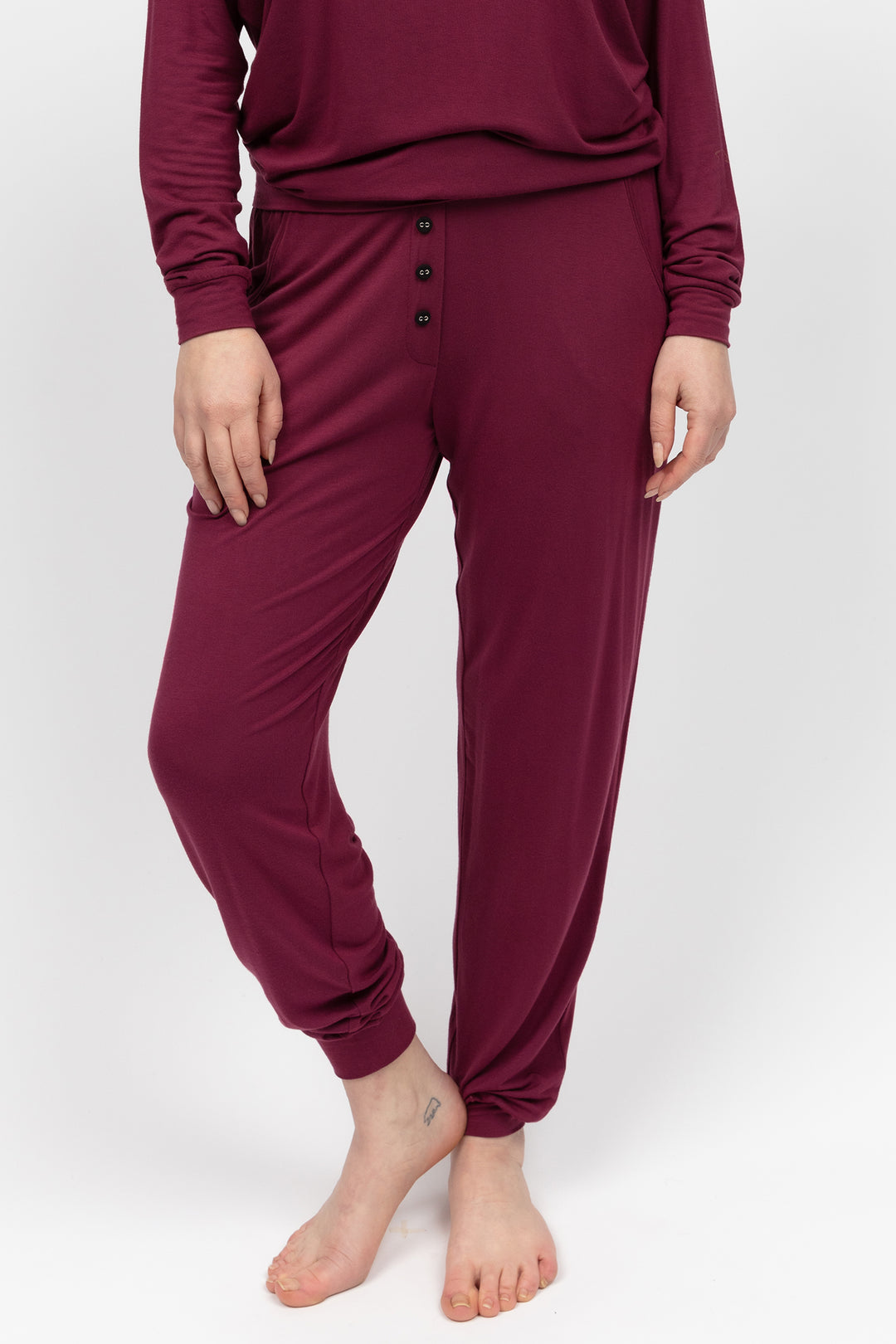 Maroon pajama set worn by a person on a white background