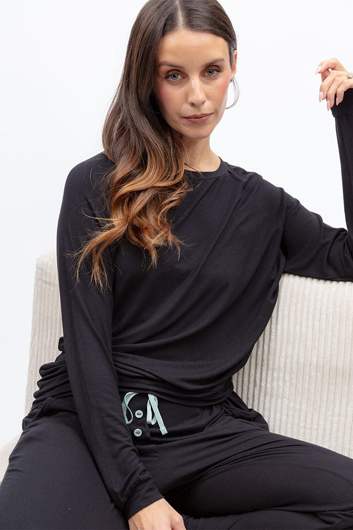 Cyberjammies 5580 Grace Black Slouch Jersey Long Sleeve Pyjama Top, worn sitting on a sofa