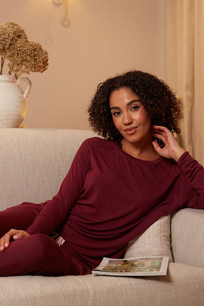 Cyberjammies 5688 Blush Botanica Berry Red Slouch Jersey Long Sleeve Pyjama Top, worn on a sofa