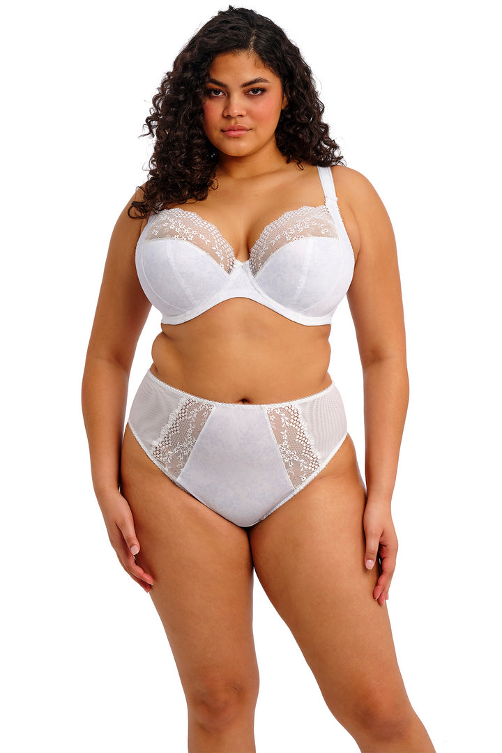 Woman wearing a white lace bra and panties set on a white background