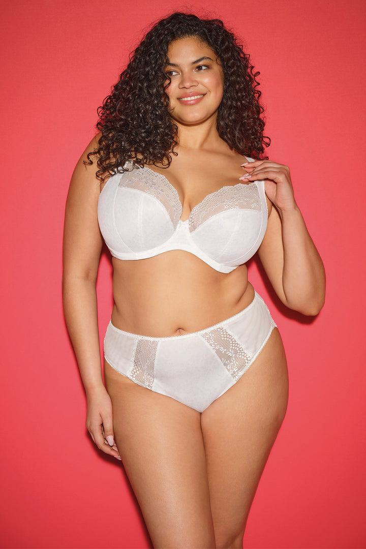 Woman wearing a white bra and panties set against a red background