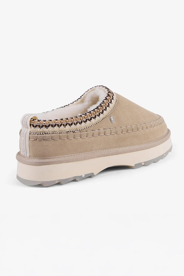 Beige slip-on shoe with white fur lining on a white background