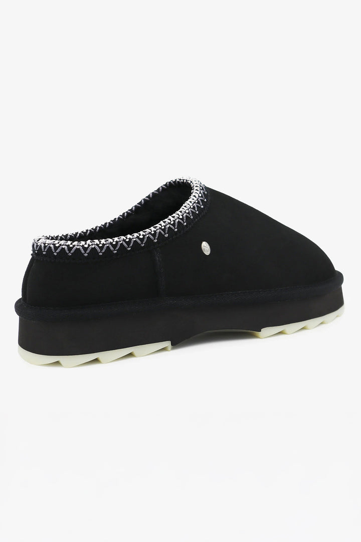 Black slipper with decorative trim on a white background