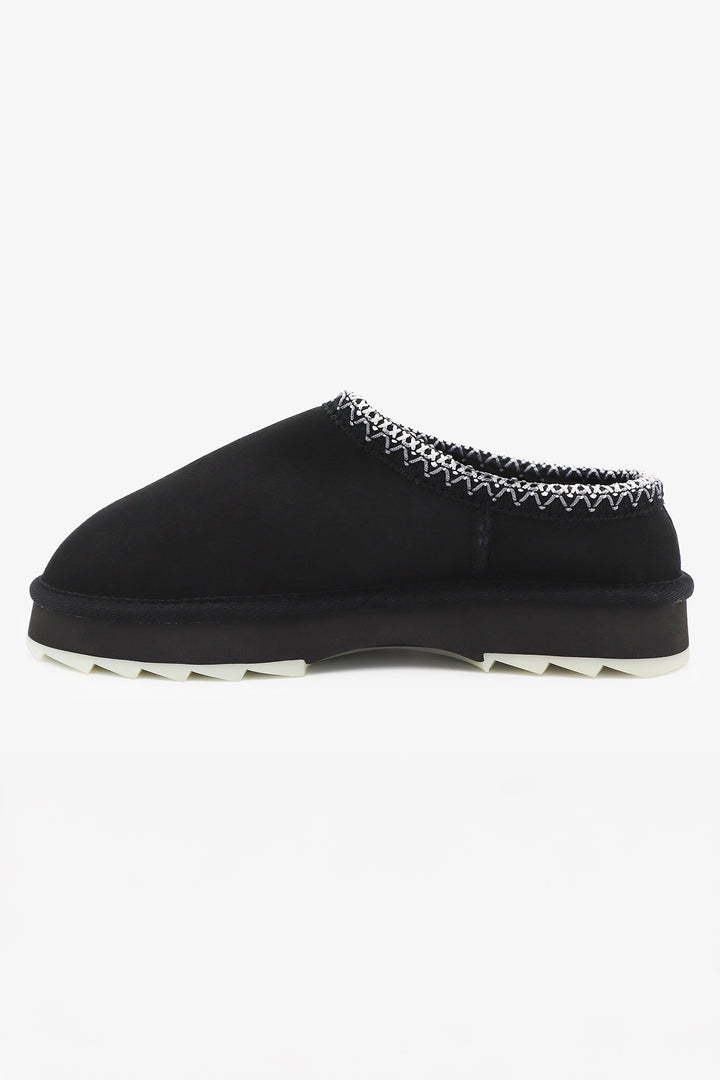 Black slip-on shoe with decorative trim on a white background