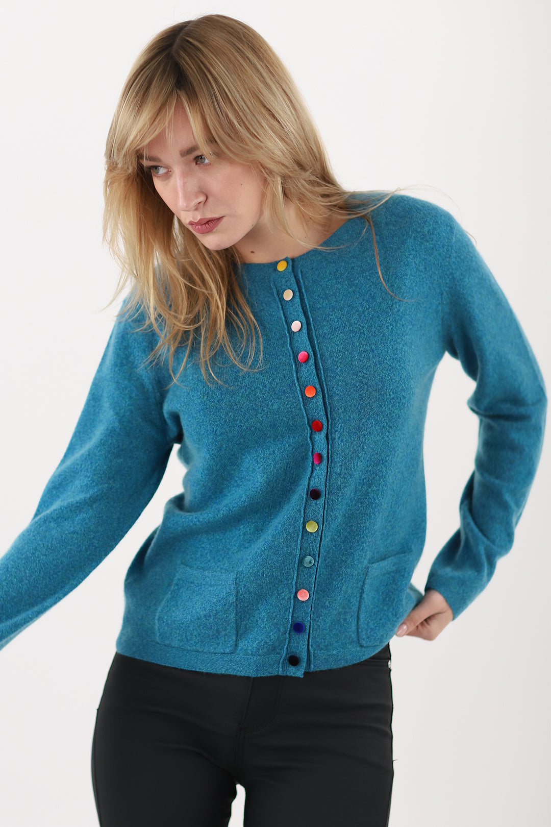 Woman wearing a blue cardigan with colorful buttons on a white background