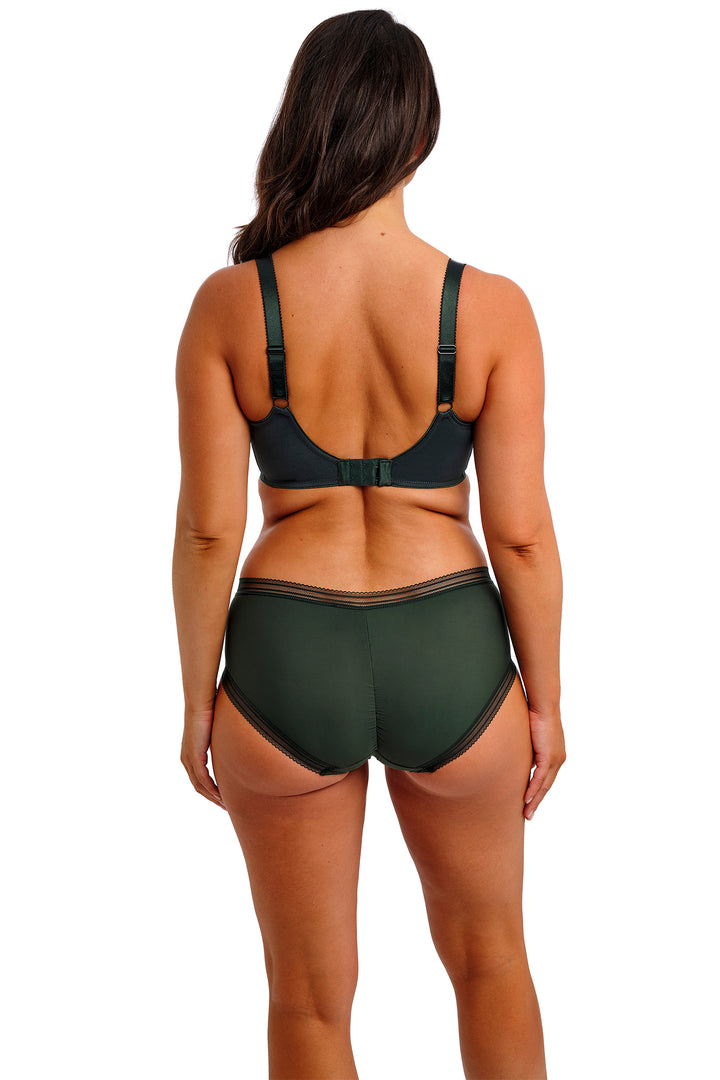 Person wearing a green bra and underwear set on a white background